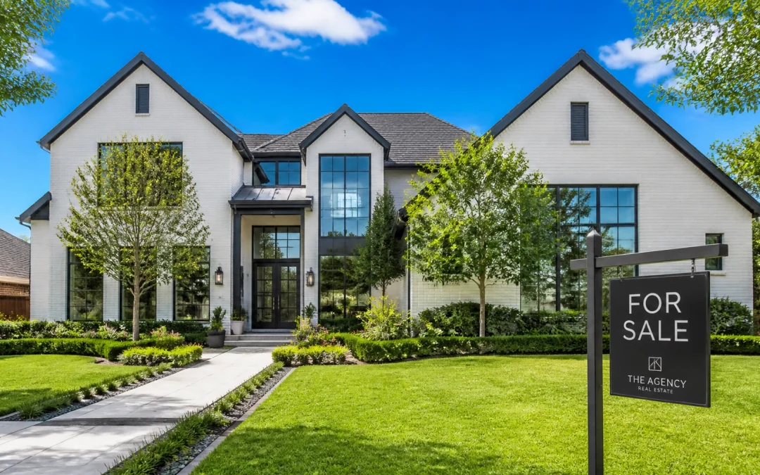 A modern Houston suburban home during a bright summer day with professional landscaping and a for sale sign