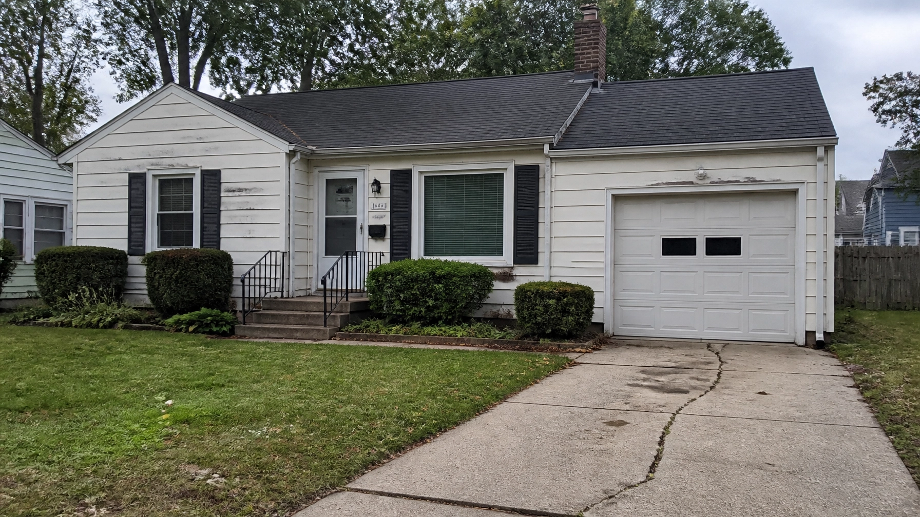 A house with visible maintenance needs like a cracked driveway