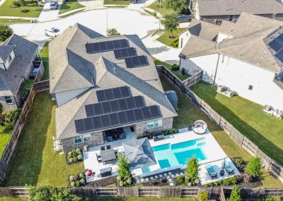 Aerial view of 26107 Pond Lily Circle home with solar panels, pool, and landscaped yard.