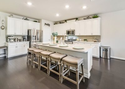 Featured Katy, Texas property kitchen with white cabinets and island seating.