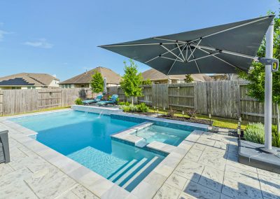 Luxury Katy Texas property featuring a pool and patio umbrella.