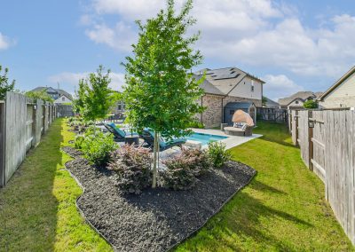 Katy, Texas property featuring a backyard pool and landscaped garden.