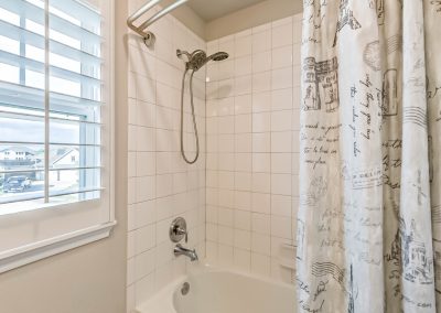 Bathroom shower with patterned curtain and window view of Katy, Texas property.