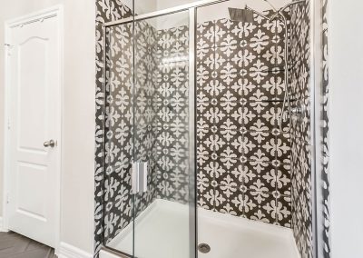 Stylish bathroom shower with patterned tile and glass door in Katy, Texas property listing.