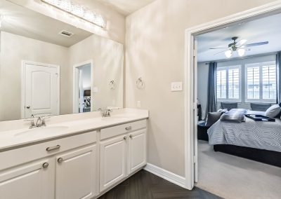 Bathroom interior with double vanity and view of bedroom in Katy, Texas property listing.