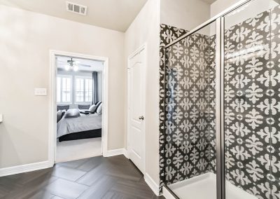 Bathroom interior with patterned shower and doorway to bedroom in Katy, Texas property.