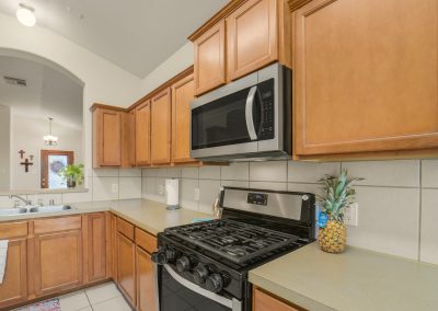Kitchen interior with stainless steel appliances and wood cabinetry in Katy, Texas property listing.