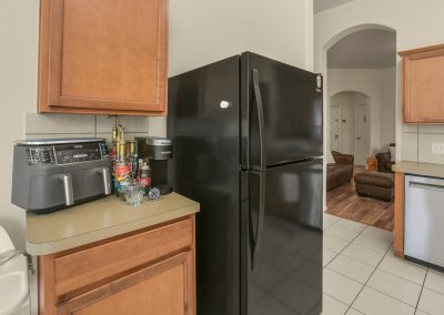 Kitchen interior with stainless steel appliances and modern refrigerator in Katy, Texas property listing.
