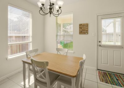 Dining area with light fixture and windows in Katy, Texas home for sale.