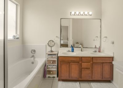 Bathroom interior with double vanity and bathtub in Katy, Texas property listing.