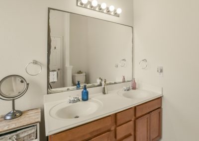 Bathroom vanity with double sinks and mirror in Katy Texas property listing.