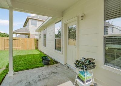 Exterior view of home in Katy, Texas featuring backyard and covered patio.