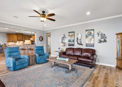 Living room interior with sofa, chairs, and ceiling fan in Galveston, Texas property.