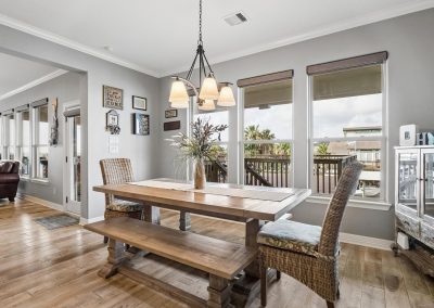 Dining area with wood floors and large windows in Galveston, Texas property for sale.