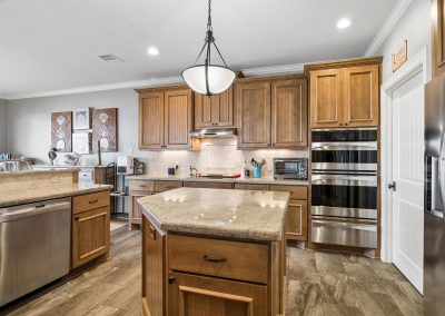 Modern kitchen with wood cabinetry and stainless steel appliances in Galveston, Texas property.