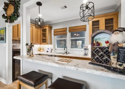 Kitchen interior with marble countertops, wooden cabinetry, and wine rack in Galveston, Texas property.