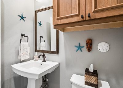 Bathroom interior with white sink, mirror, and decorative accents for sale in Galveston, Texas.