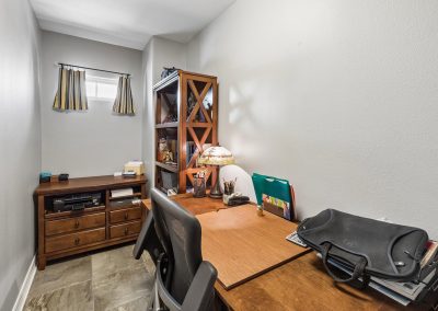Interior view of home office with desk and wood shelving in Galveston, Texas property.