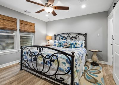 Bedroom interior with decorative bed and window, featured property for sale in Galveston, Texas