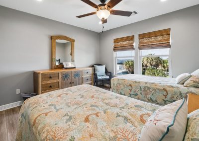 Bright bedroom interior with bed, mirror, and window view in Galveston, Texas property.