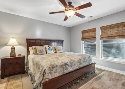 Bedroom interior with ceiling fan and blinds, featured property for sale in Galveston, Texas.