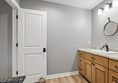 Interior of Galveston, Texas home featuring bathroom with white door and vanity.