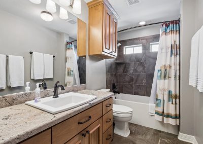 Modern bathroom interior with granite countertop and tiled shower in Galveston, Texas property.