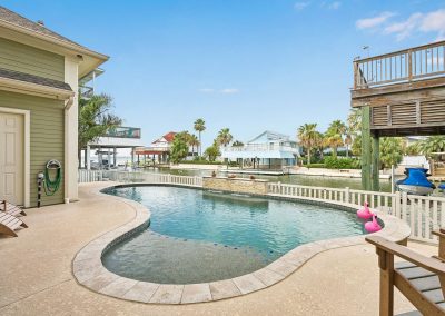 Luxury waterfront home with pool and boat dock in Galveston, Texas.