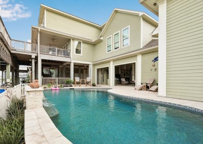 Luxury home exterior with pool and patio in Galveston, Texas.