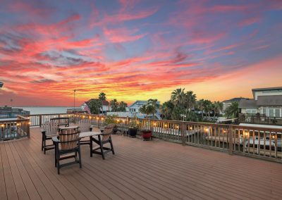 Luxury waterfront home with sunset view and outdoor seating area, Galveston, Texas.