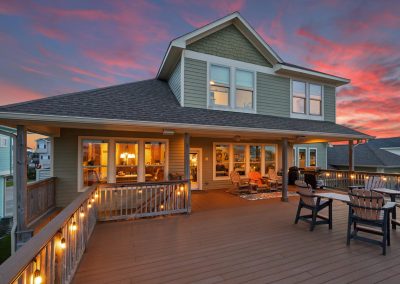 Large two-story home with expansive deck and Houston sunset
