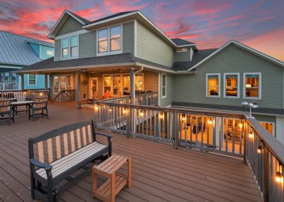 Luxury home with expansive deck and outdoor lighting, featured property for sale in Galveston, Texas.