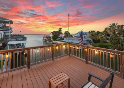 Luxury waterfront property in Galveston, Texas at sunset with American flag.