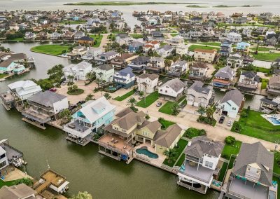 Aerial view of waterfront homes in Galveston, Texas, featured property for sale by Bexley Realty Group.